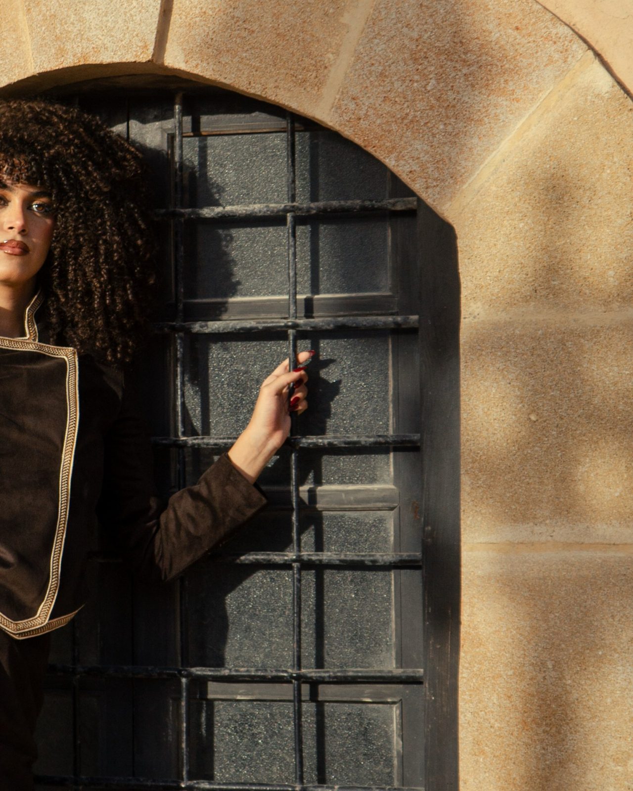 Model standing in an arched doorway