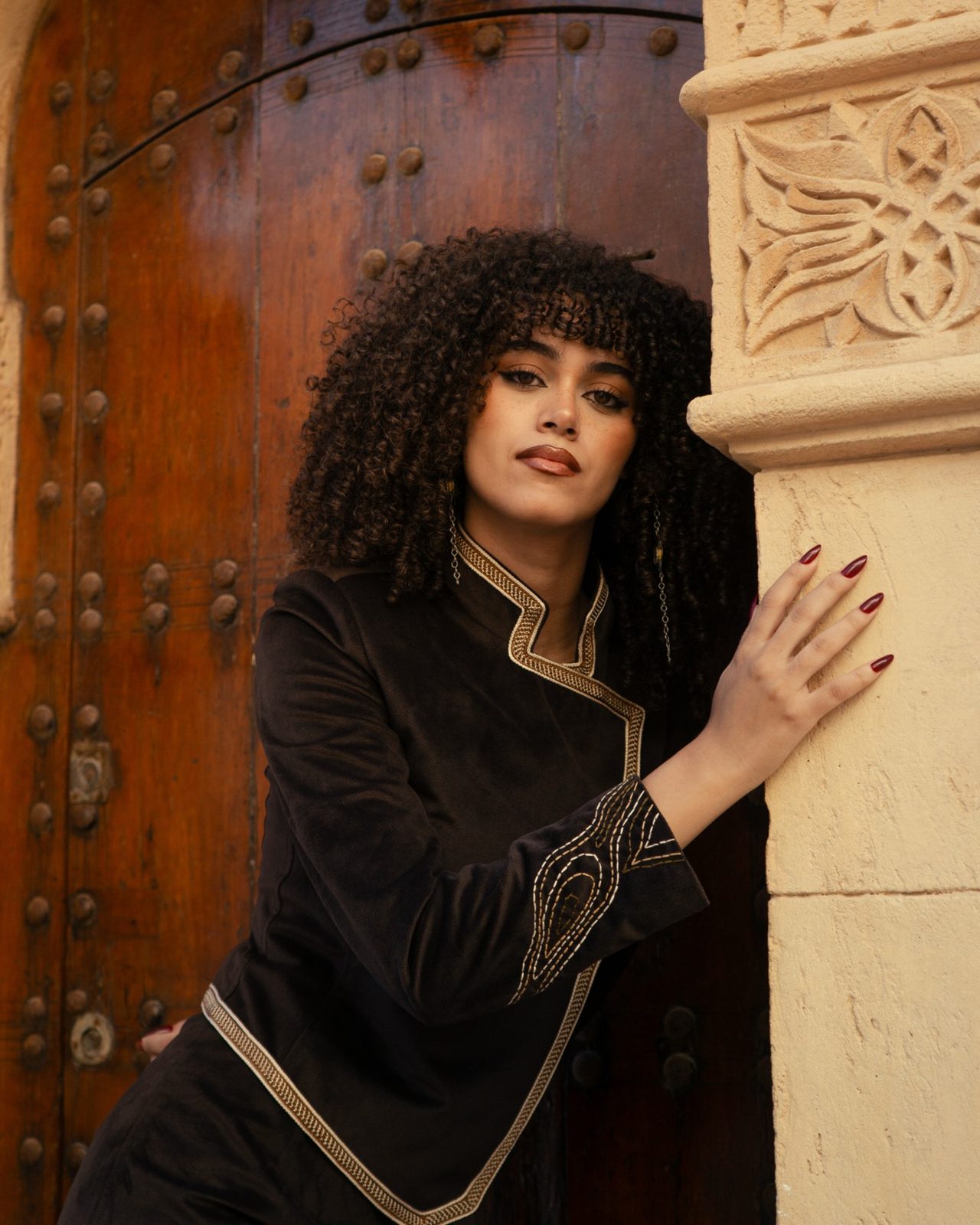 Second Layer jacket against a carved wooden door
